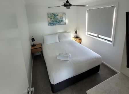 A photo of one of the bedrooms in our executive cabins. This bedroom has a double bed with a crisp with bedcover.