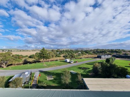 A view from a high vantage point of the camp sites, which are beautiful and green and situated under large pine trees.