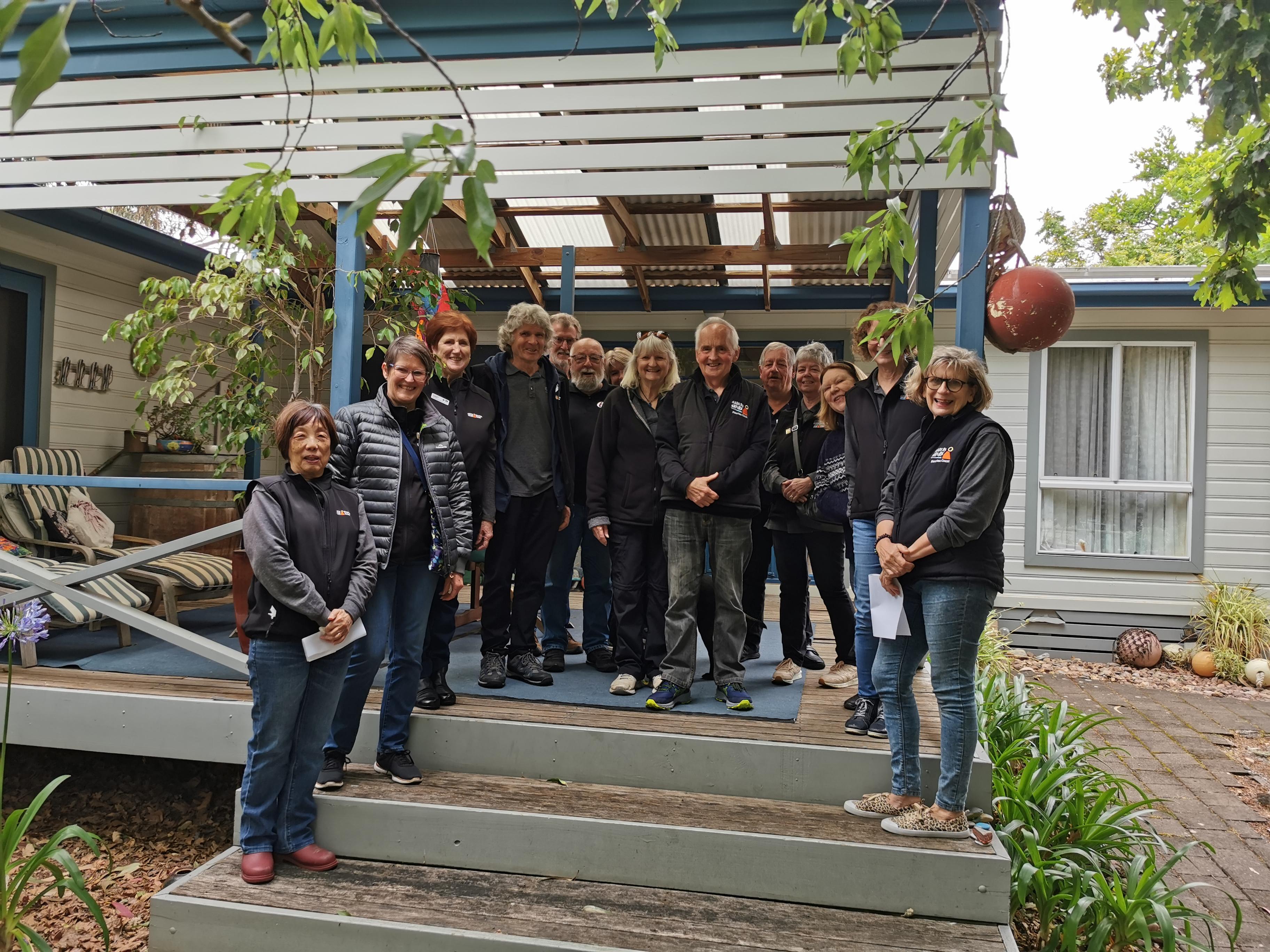 A group of volunteers standing on a deck and smiling at the camera