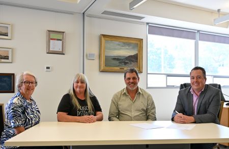 A photo of Lorraine Felix, Amanda Crossley, Mayor Darryl Houston and CEO Nathan Cunningham sitting at a table and smiling at the camera