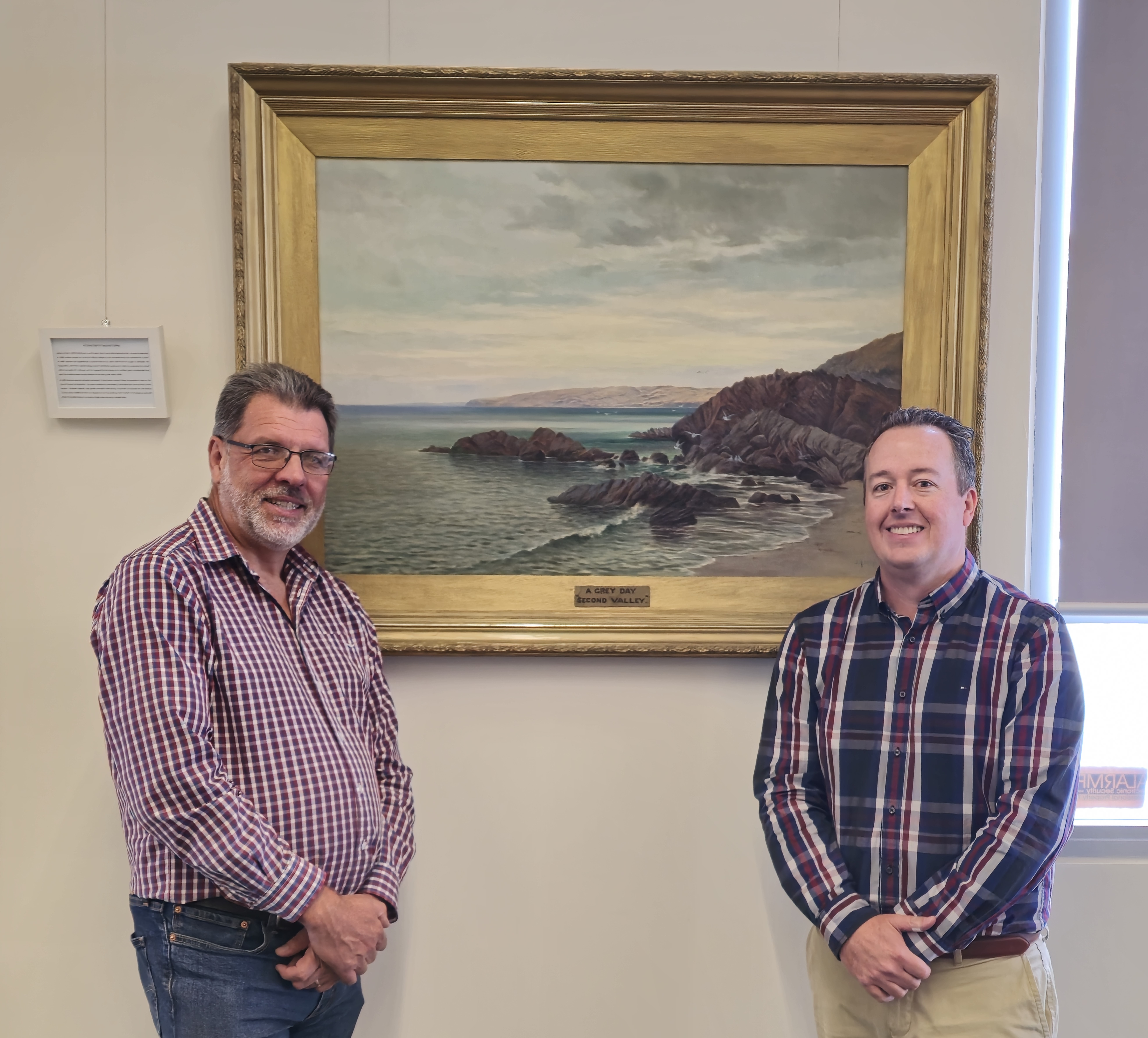 Mayor Houston and CEO Nathan Cunningham standing either side of a painting. They are both smiling.