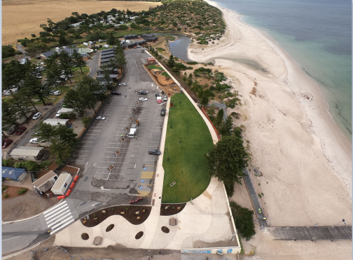 A birds eye view of a park and carkpark next to the beach
