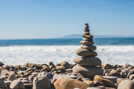 Pebbles balancing from biggest to smallest on a rocky beach